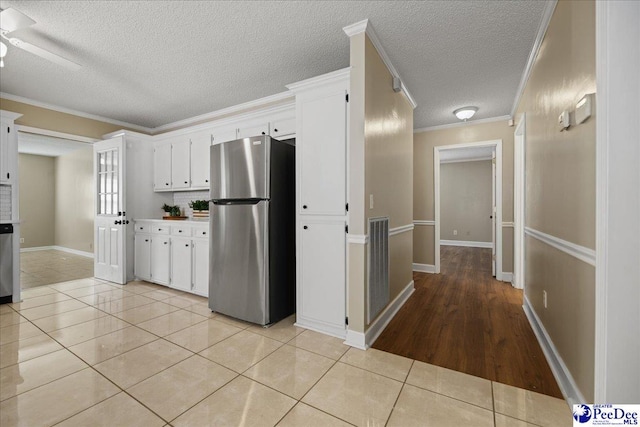 838 Greenwing Teal, Florence, SC 29505 - kitchen featuring a textured ceiling, appliances with stainless steel finishes, light tile patterned flooring, and white cabinets