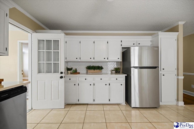 838 Greenwing Teal, Florence, SC 29505 - kitchen with light tile patterned floors, crown molding, white cabinets, decorative backsplash, and appliances with stainless steel finishes
