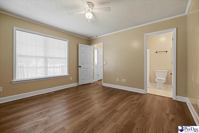 838 Greenwing Teal, Florence, SC 29505 - unfurnished bedroom featuring visible vents, ornamental molding, a textured ceiling, connected bathroom, and wood finished floors