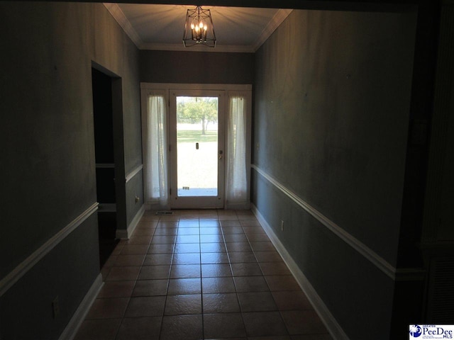 doorway to outside featuring a chandelier, baseboards, tile patterned flooring, and crown molding