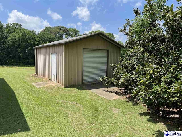 view of outdoor structure featuring a garage and a yard