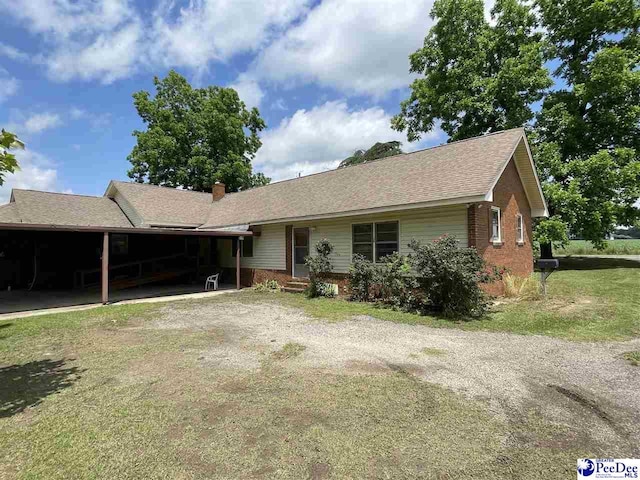 ranch-style home with a carport and a front yard