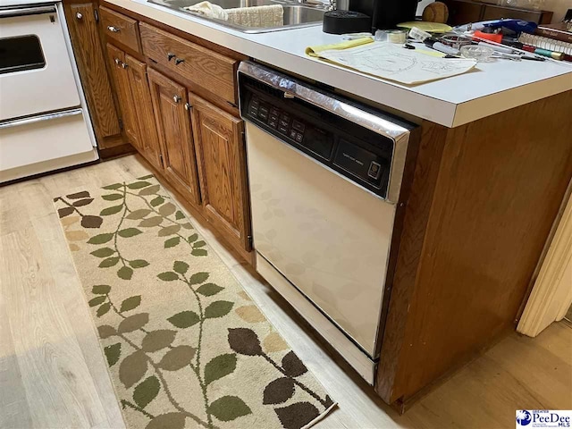 kitchen with sink, white appliances, and light wood-type flooring