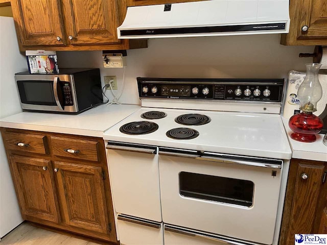 kitchen with wall chimney exhaust hood and white range with electric cooktop