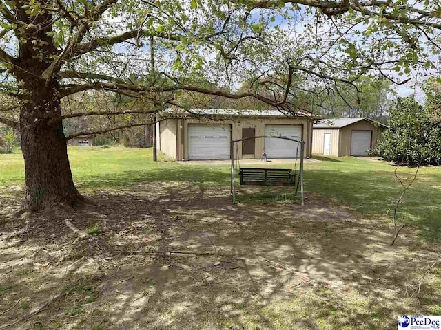 view of yard featuring a garage and an outdoor structure