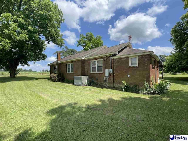 back of property with cooling unit and a lawn