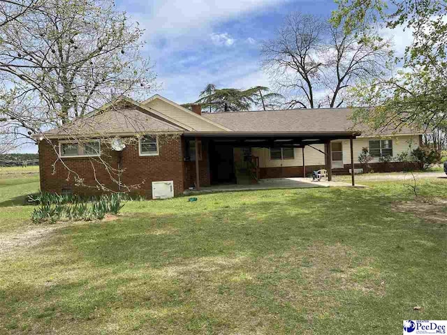 rear view of house with a carport and a lawn