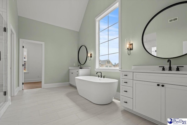 2528 Edinberg Way, Florence, SC 29501 - bathroom featuring two vanities, a soaking tub, plenty of natural light, baseboards, and high vaulted ceiling
