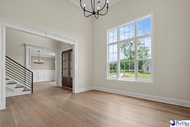2528 Edinberg Way, Florence, SC 29501 - unfurnished dining area featuring a chandelier, wood finished floors, stairway, a wainscoted wall, and a decorative wall