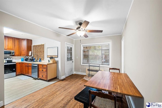 600 Greenway Dr, Florence, SC 29501 - kitchen featuring brown cabinetry, stainless steel appliances, light countertops, light wood-style floors, and backsplash