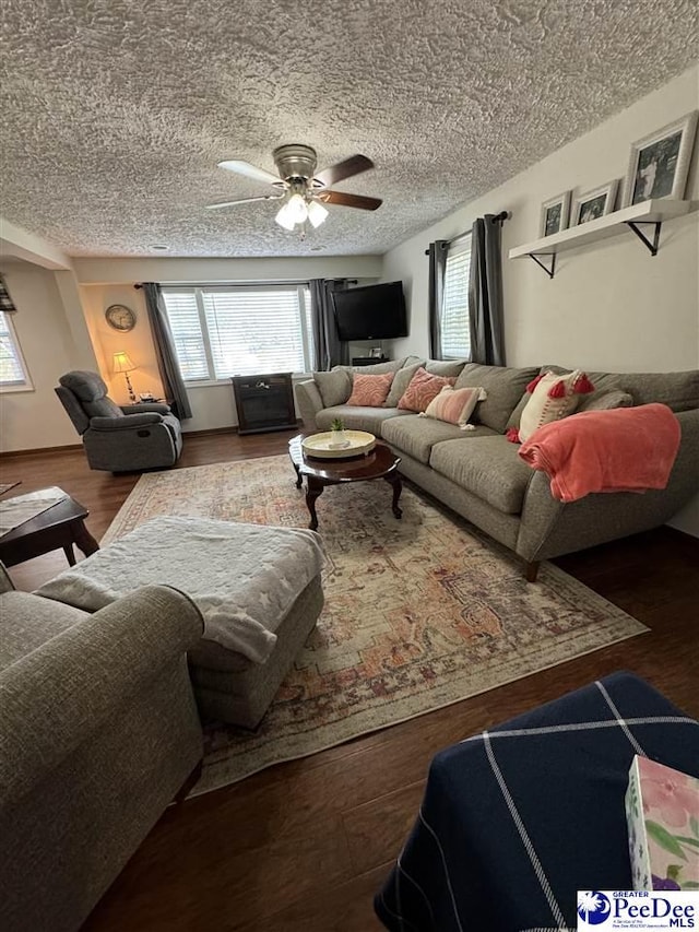 living room featuring ceiling fan, wood-type flooring, and a textured ceiling