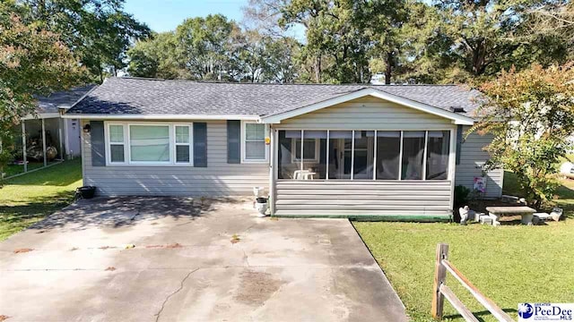 single story home featuring a sunroom and a front lawn