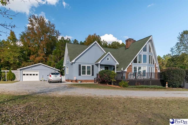 view of front of home featuring a garage, an outdoor structure, a front lawn, and a deck