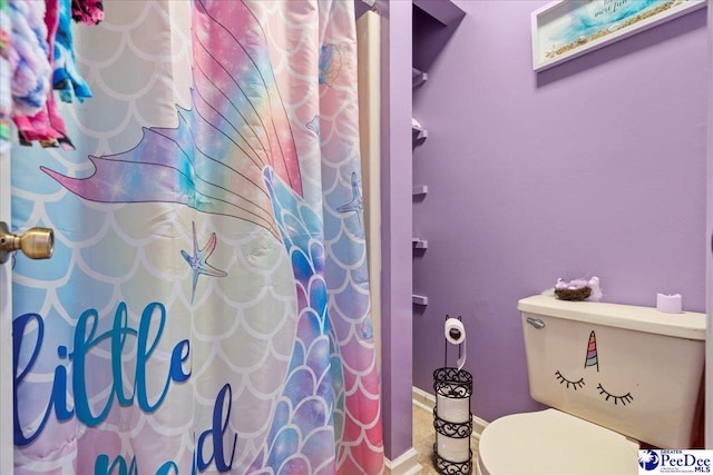 bathroom with a shower with curtain and toilet