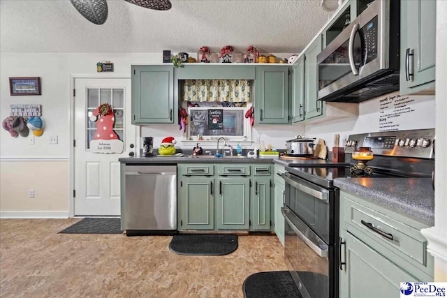 kitchen featuring sink, a textured ceiling, green cabinetry, and appliances with stainless steel finishes