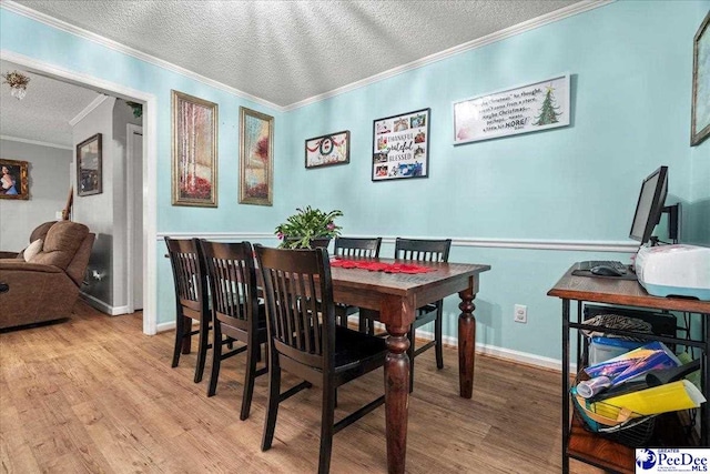 dining room with crown molding, light hardwood / wood-style floors, and a textured ceiling