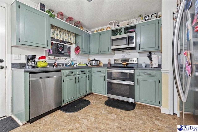 kitchen featuring stainless steel appliances, a textured ceiling, and green cabinets