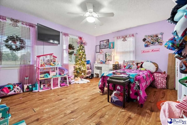 bedroom with hardwood / wood-style floors, a textured ceiling, and ceiling fan