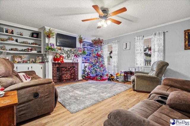 living room with crown molding, a textured ceiling, a brick fireplace, and light wood-type flooring