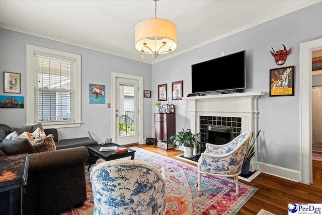 318 Mcleod St, Florence, SC 29501 - living room featuring wood finished floors, crown molding, a tiled fireplace, and a chandelier
