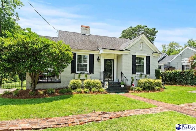 318 Mcleod St, Florence, SC 29501 - view of front of house with brick siding, a chimney, a front yard, and roof with shingles