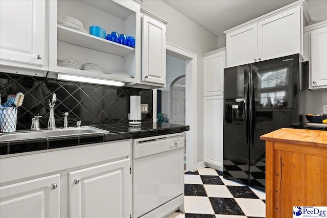 318 Mcleod St, Florence, SC 29501 - kitchen with white dishwasher, black fridge, tile patterned floors, white cabinetry, and tasteful backsplash