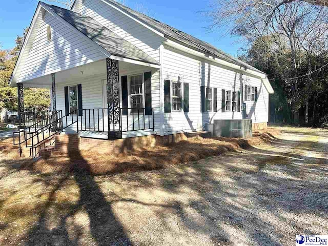 view of side of home featuring covered porch