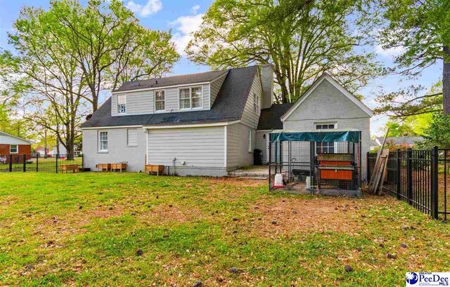 back of property with a fenced backyard and a yard