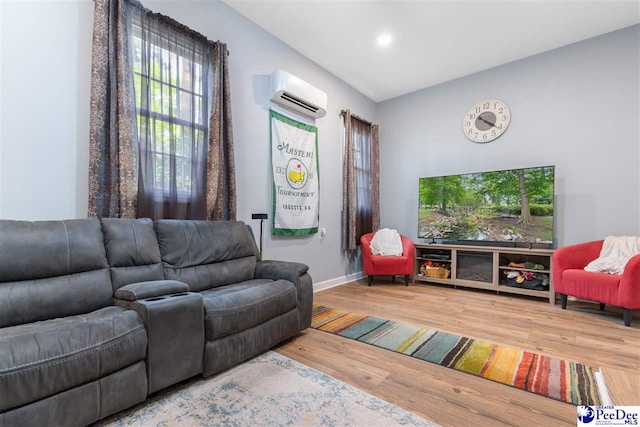 living area featuring baseboards, wood finished floors, and a wall mounted AC