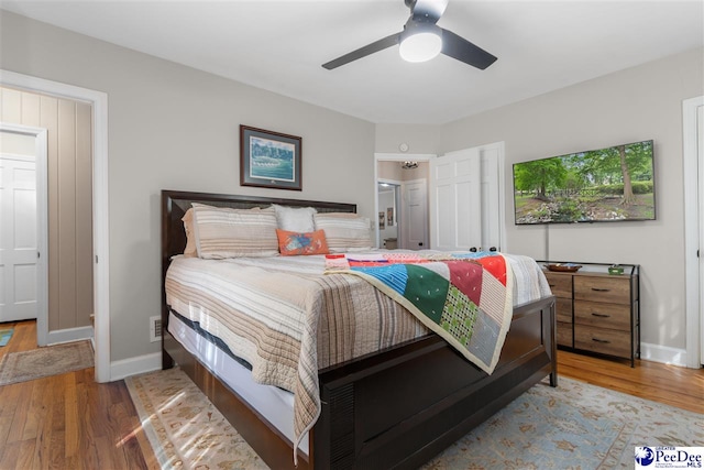 bedroom with wood finished floors, a ceiling fan, and baseboards