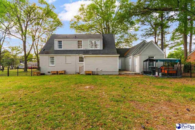 back of house featuring fence, a lawn, and entry steps