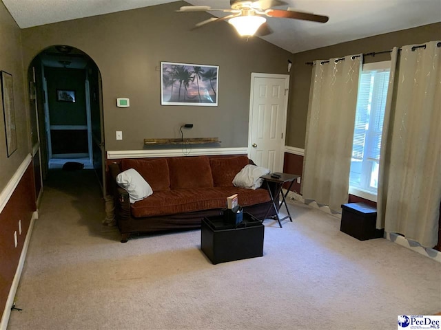 carpeted living room with vaulted ceiling and ceiling fan