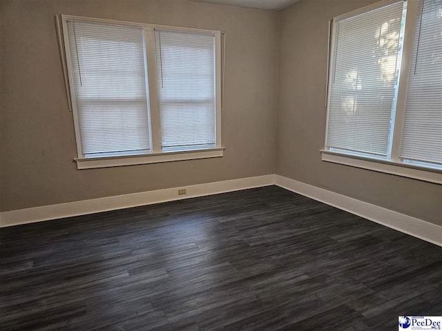 empty room with dark hardwood / wood-style flooring