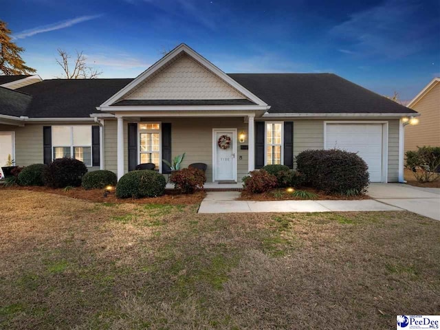 ranch-style home featuring a garage and a yard