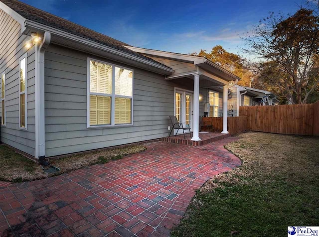 back house at dusk with a patio area