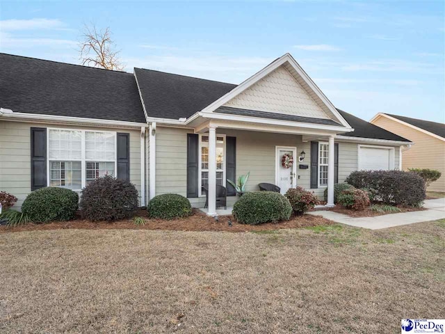 ranch-style home with a garage, covered porch, and a front lawn