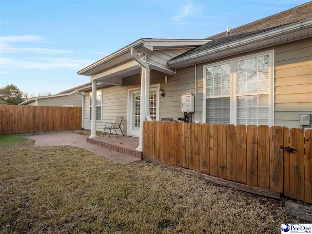 rear view of property featuring a lawn and a patio area