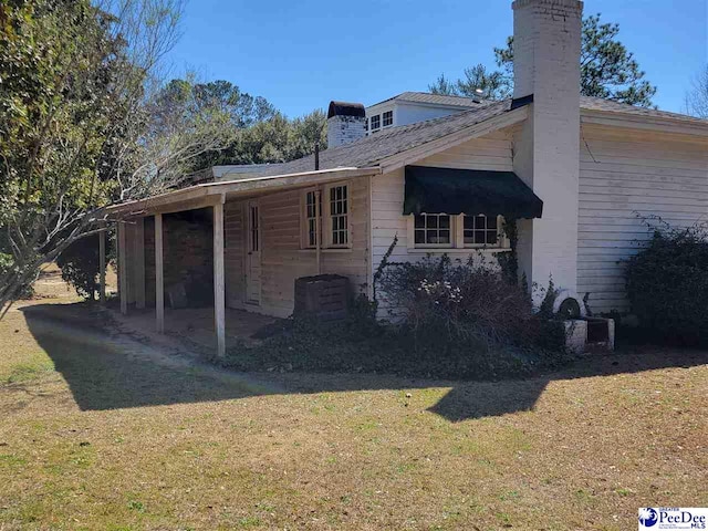 601 Cashua St, Darlington, SC 29532 - view of property exterior with a chimney, a yard, and a patio area