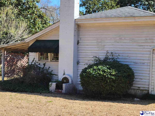601 Cashua St, Darlington, SC 29532 - view of home's exterior with a chimney, roof with shingles, and a lawn