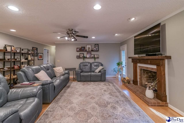 100 Warren Way, Cheraw, SC 29520 - living room with light wood-type flooring, ceiling fan, a textured ceiling, a brick fireplace, and crown molding