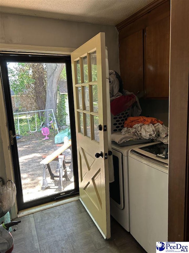 clothes washing area with a textured ceiling and washing machine and dryer