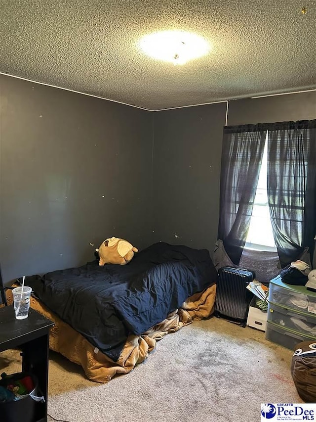 bedroom featuring a textured ceiling and carpet