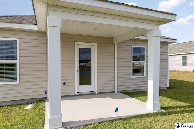 entrance to property with a yard and a patio