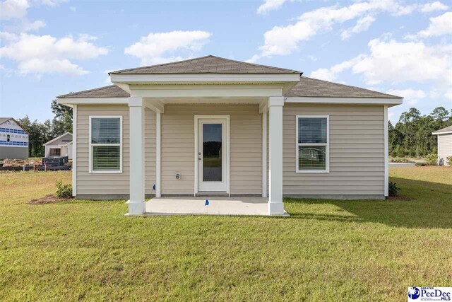 rear view of property with a yard and a patio