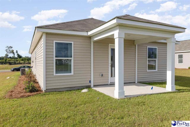 back of property with a yard and a patio