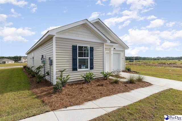 view of side of property with a garage and a lawn