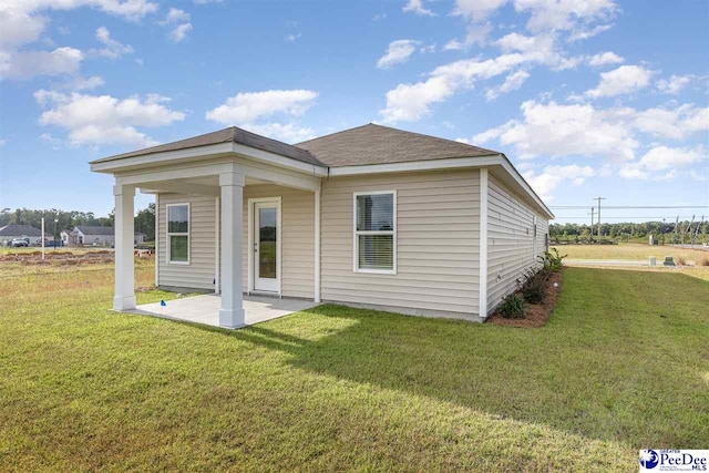 rear view of house with a yard and a patio