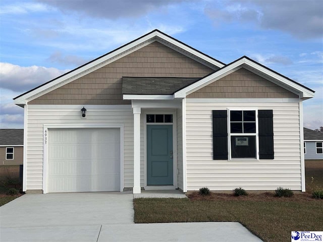 view of front of home featuring a garage and a front lawn