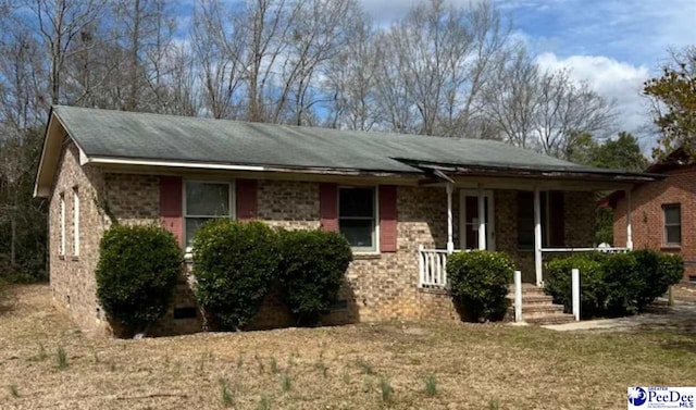 single story home featuring brick siding and a porch