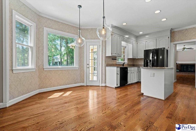 3427 Sussex Ct, Florence, SC 29501 - kitchen with black appliances, wallpapered walls, ornamental molding, wood finished floors, and white cabinetry